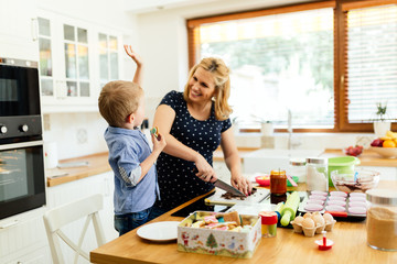 Child helping mother make cookies