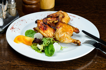 Appetizing spicy baked mini chicken on the plate in Italian rest
