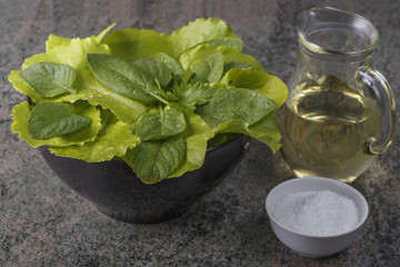 A top view of a mixture of fresh leaves. Salts and oils for salad preparation