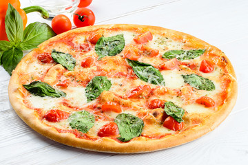 Delicious homemade Italian pizza with cheese, tomatoes and basil