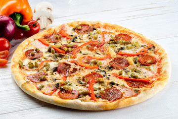 Appetizing hot Italian pizza with cheese, salami and pepper on r