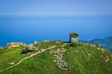 Alpine landscape with small soldiers monument facing the Mediteranean Sea in Beigua National...