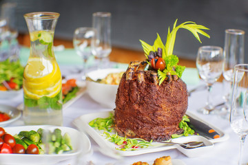 Rolled pork ribs with vegetables on a with plate on a table.