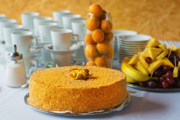 Simple whole orange cake with crumbs on a table.