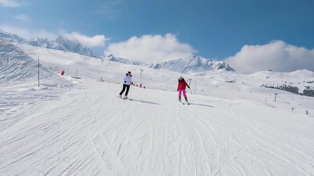 Two Woman Skiers Skiing Down The Ideal Slope Of The Mountain In Winter