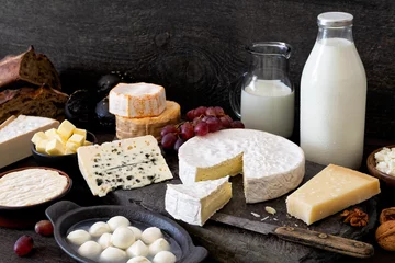 Foto auf Acrylglas Milchprodukte Käse, Milch und Milchprodukte auf rustikalem dunklem Holz und Schieferhintergrund.