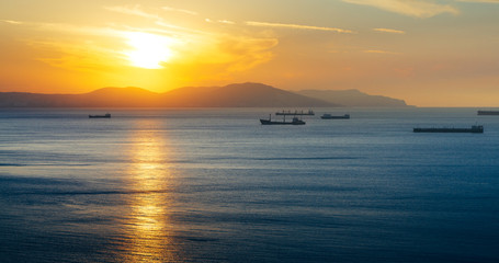 Naklejka na ściany i meble Bulk-carrier Ship At Sunset In The Sea On Sunset. Gelendzhik, Russia