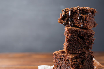 Homemade brownies on dark moody background. Chocolate cake closeup. Copy space.