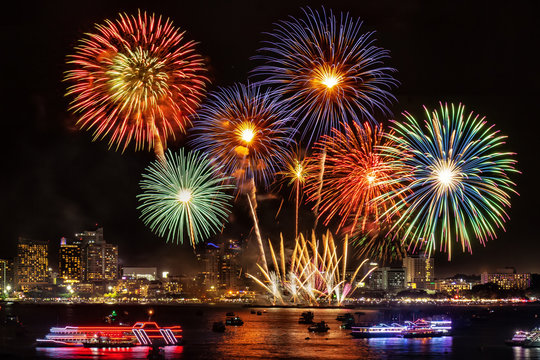 festive colorful firework light up the sky over the city at night scene for holiday festival and celebration background