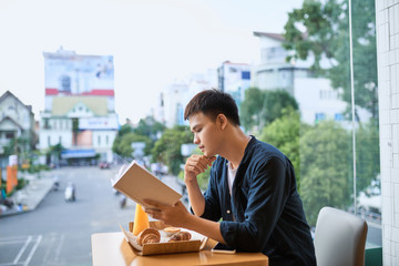 Man reading a book in a coffee shop