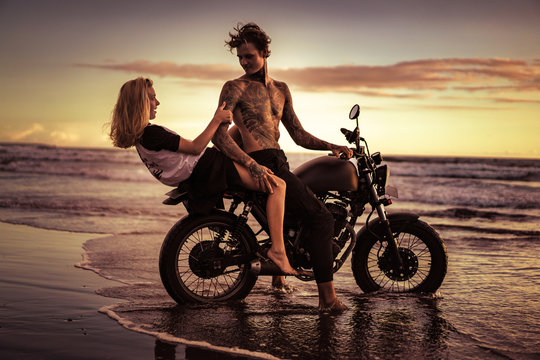 couple having fun on motorcycle at ocean beach