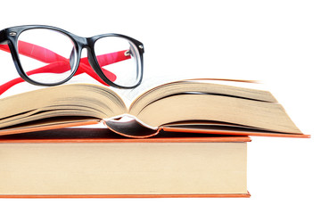 Open book and glasses on a stack of books