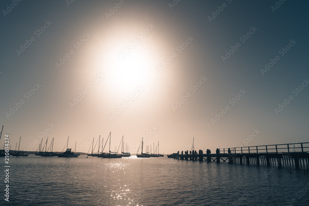 Wall mural Yachts and wooden jetty at the sea