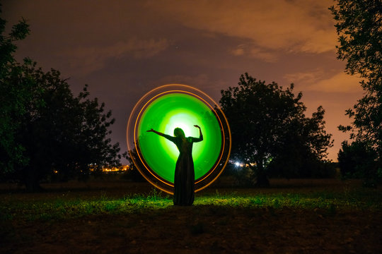 Female silhouette in glowing circle in nature