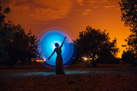 Female silhouette in glowing circle in nature
