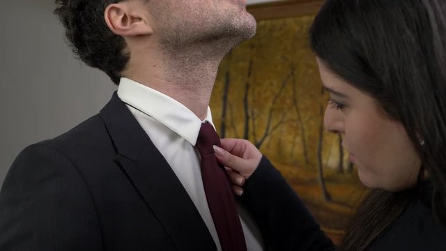sweet wife arranges the tie to her husband before he goes to work- slow motion
