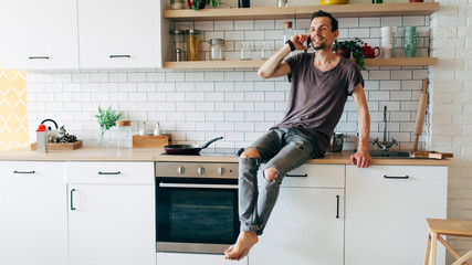 Photo of man sitting in kitchen talking on phone