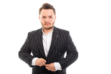 Portrait of young business man buttoning up jacket.