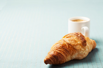 Breakfast setting with coffee and croissant