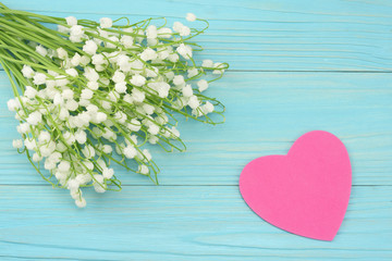 lilies of the valley on a blue wooden background. top view