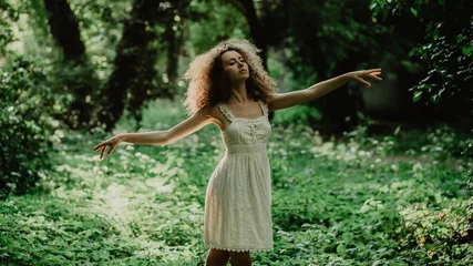Tuinposter Young and beautiful girl dancing ballet in the secret garden. Natural scenery in the forest. © FollowTheFlow