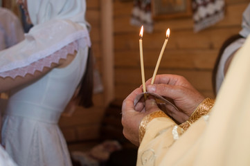 the priest holds candles inside the church