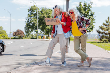 Great mood. Joyful happy people laughing while hitchhiking