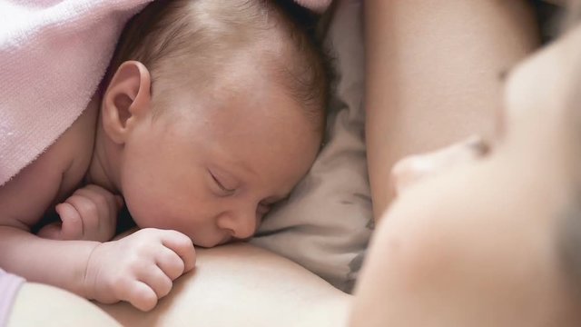 mother feeds her newborn breast