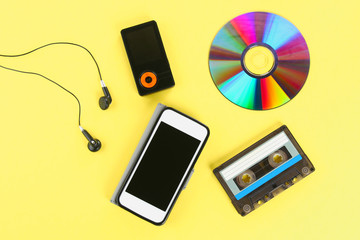 The concept of the evolution of music. Cassette, CD-disk, mp3 player, mobile phone. Vintage and modernity. Music support.