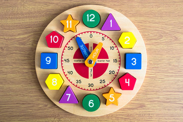 Toy wooden clock on a wooden background