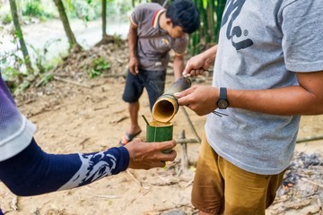 Pouring out hot water out of a piece of bamboo