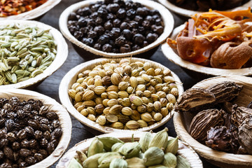 Group of indian spices in coconut bowls on wooden background