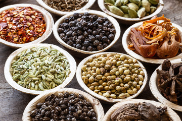 Group of indian spices in coconut bowls on wooden background