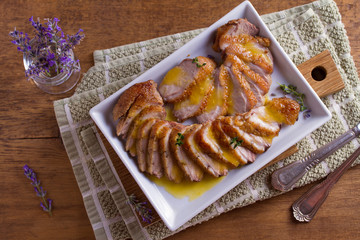 Sliced duck breast with orange sauce and thyme. View from above, top studio shot