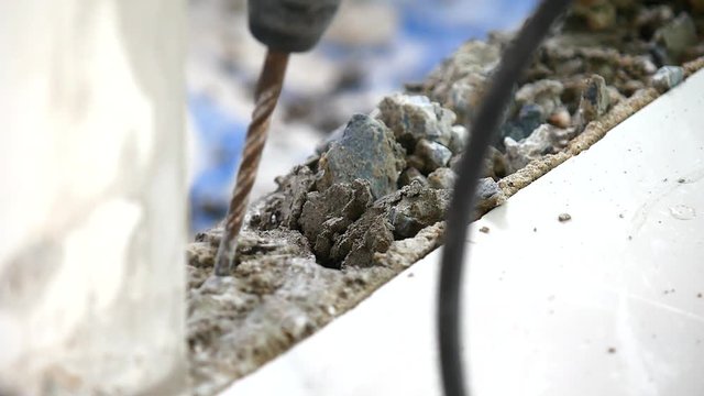Construction workers using a jackhammer to break concrete