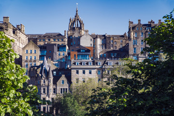 Fototapeta premium Widok na Stare Miasto w Edynburgu ze słynnych ogrodów Princes Street. Szkocja, Wielka Brytania. Iglica pośrodku linii horyzontu to katedra św. Idziego.
