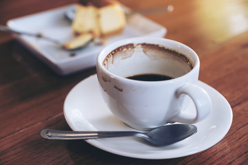 A cup of coffee and a piece of cake on table in cafe