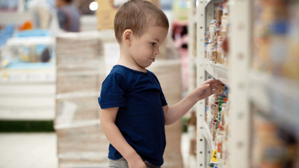 Little boy in the supermarket choose a bottle of mineral water.