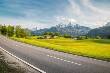 Empty asphalt country road with alpine mountain scenery in summer