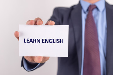 Man showing paper with LEARN ENGLISH text