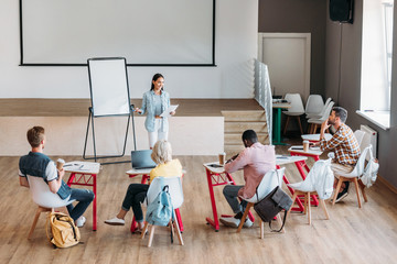 group of young students sitting in class and listening to lecture