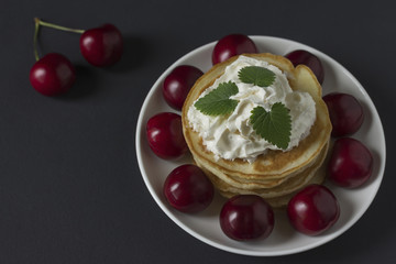 Pancakes with cherries and whipped cream