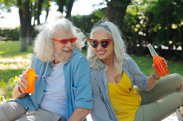 Pleasant time. Delighted joyful couple being in a good mood while having a picnic together