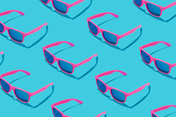 Pink sunglasses pattern on pastel blue background. Minimal summer concept. - obrazy, fototapety, plakaty