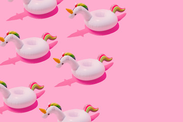 Inflatable unicorn pool toy pattern on pastel pink background with copy space. Minimal summer concept. © Zamurovic Brothers