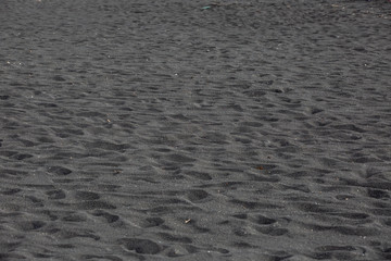 Black volcanic beach sand texture background