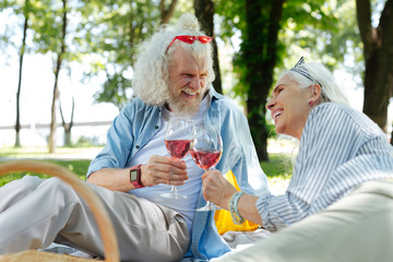 Joyful mood. Cheerful positive couple laughing while having wine together