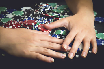 victorious rejoicing to all chips after poker game, greedy woman taking all money, toned image