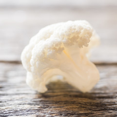 Cauliflower fresh organic, cut into small pieces on wooden background. Selective focus