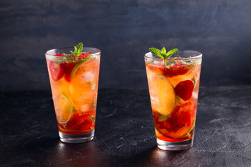 Strawberry mojito cocktail with berries, lime and mint. Summer berry cocktail on black background. space for text, horizontal